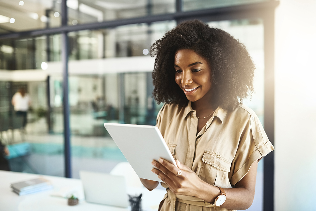 A woman alone working on a tablet.
