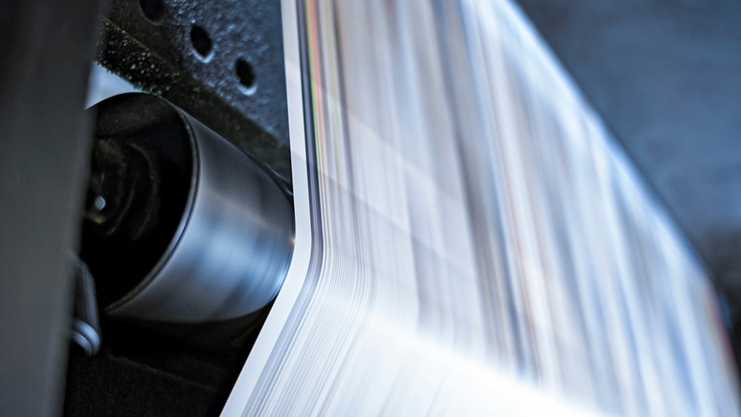 cut sheet paper is run through a machine with rollers