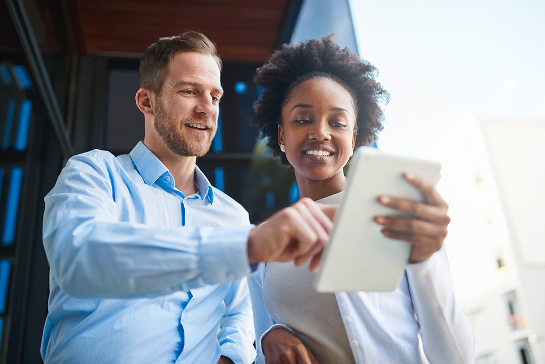 A man and woman look at a tablet together.